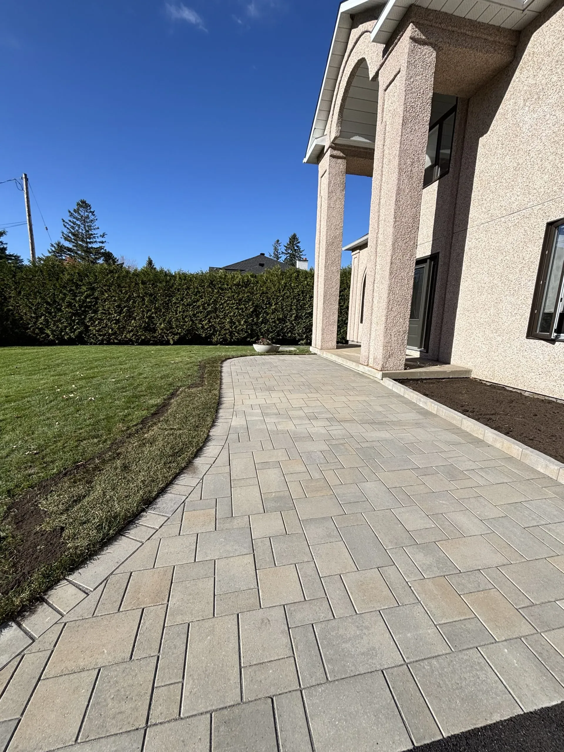 Newly installed interlock patio bordered by fresh sod in an Ottawa backyard.
